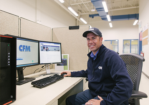 Smiling man sitting at a CFM computer workstation