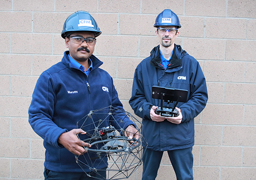 Two drone operators posing with their indoor scanning drone